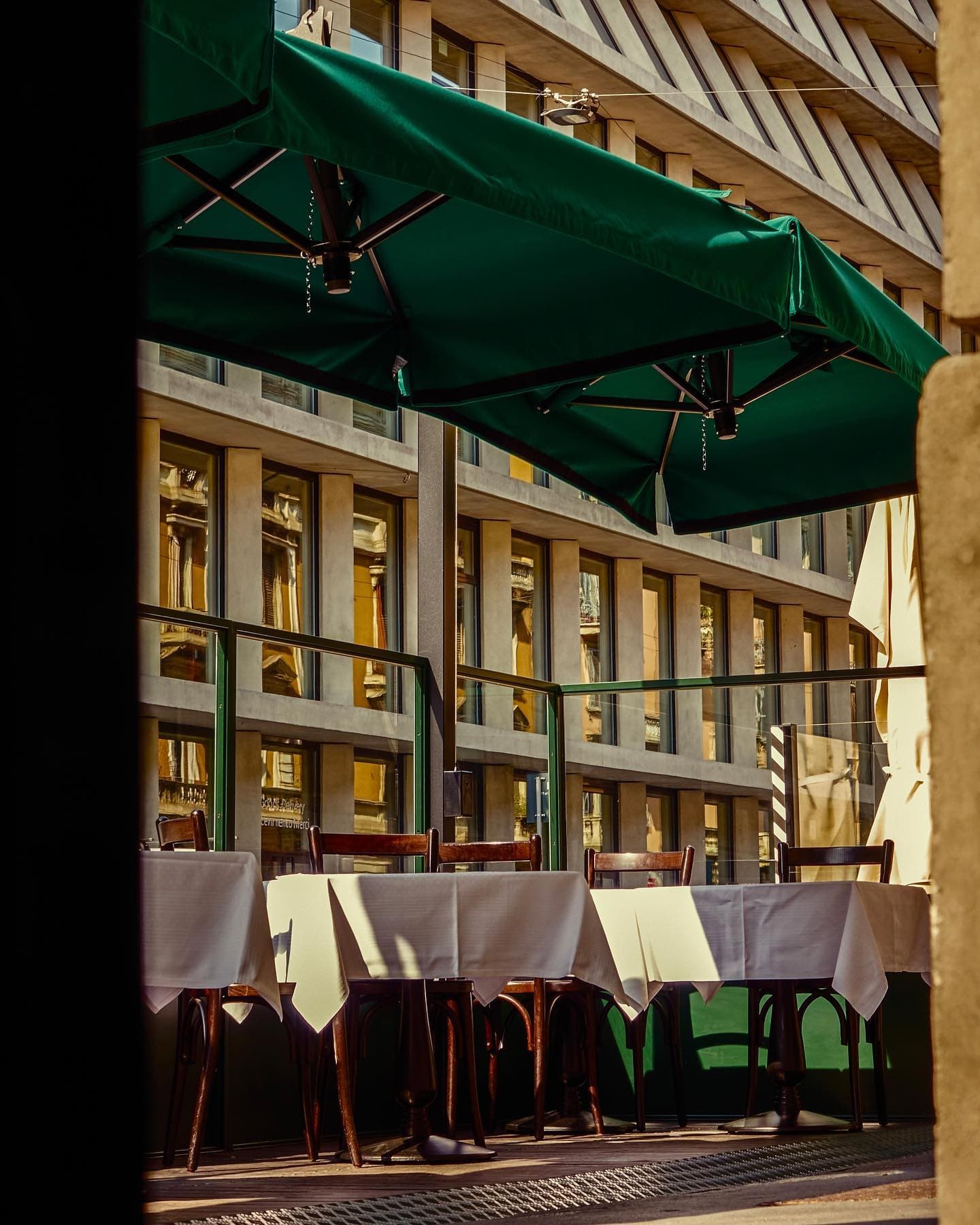 a charming restaurant terrace with green umbrellas