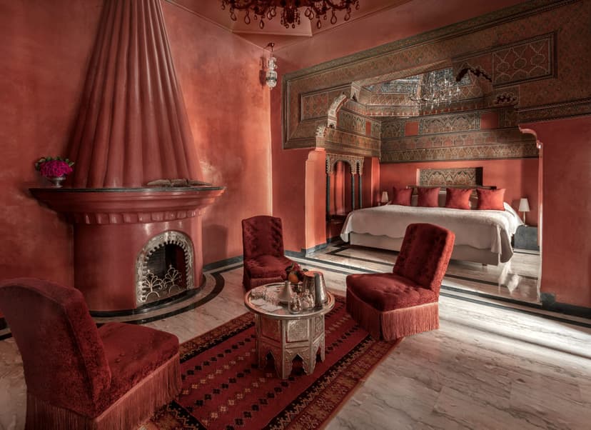 a fancy hotel room with red walls and red furniture