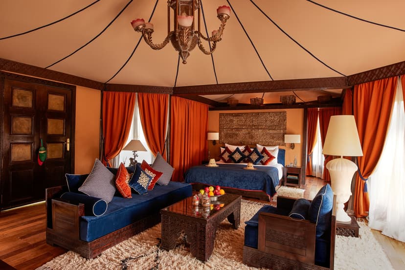 a luxe Moroccan tent with red curtains and blue furniture