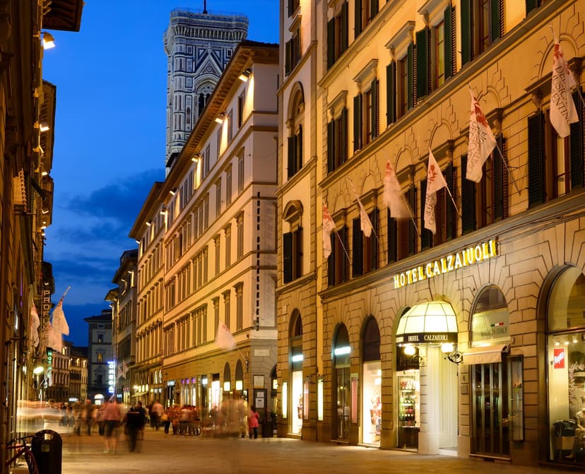 A street view of the facade of Hotel Calzaiuoli in Florence taken at night.