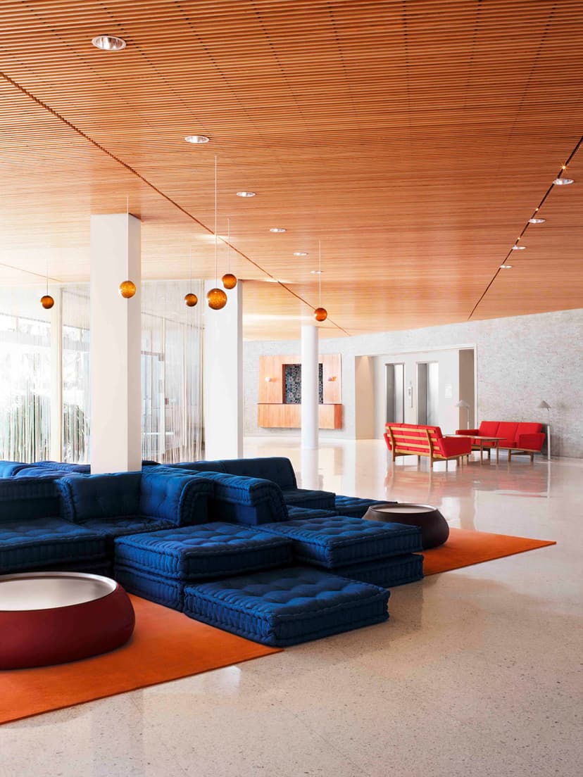 eclectic, modern lobby with navy couch and orange accents