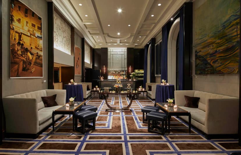 an elegant dining room with high ceilings and a red-and-blue patterned carpet