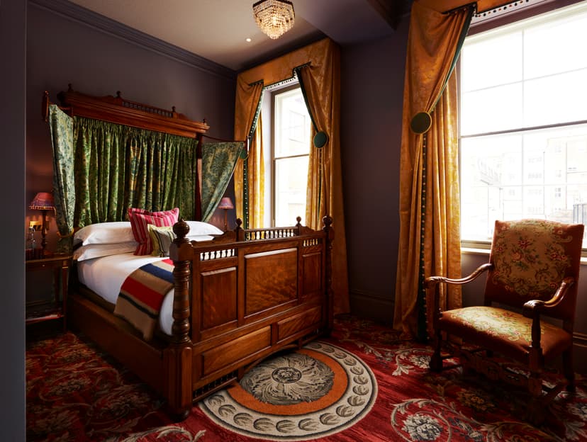 Deluxe Double room at The Zetter Marylebone with dark, vintage furniture and decoration.