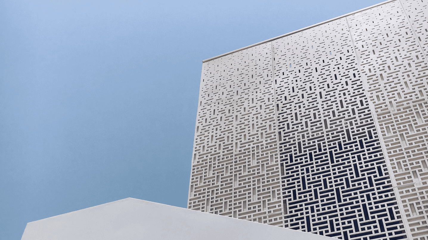 A beautiful, geometric white building in front of a clear blue sky.