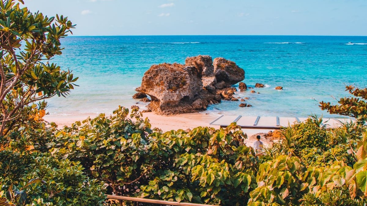 an aerial view of a bridge leading to a beach