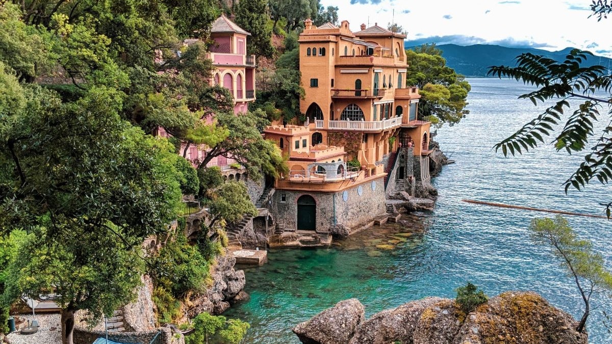 Yellow building on a cliffside near a body of water.