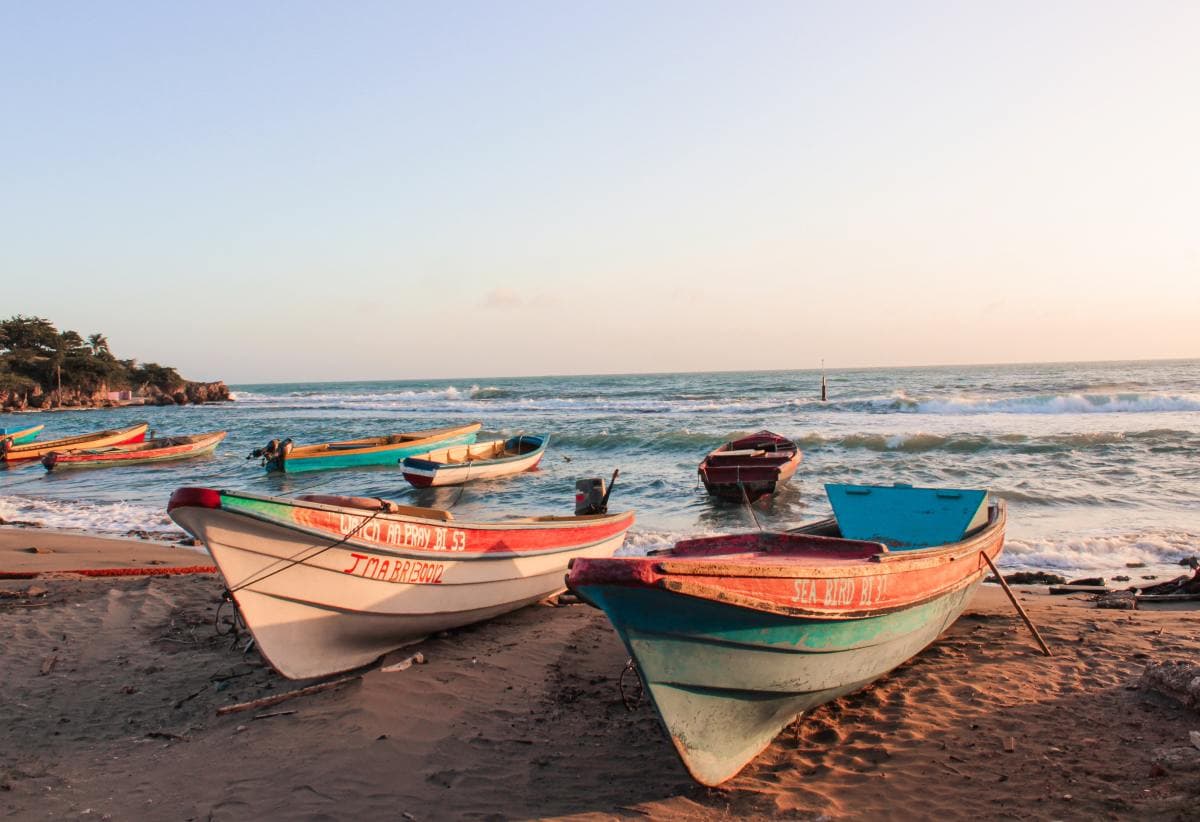 Colorful boats on the sand by the ocean in Jamaica
