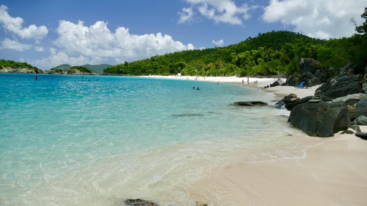 Turquoise lagoon with white-sand beach and green hills