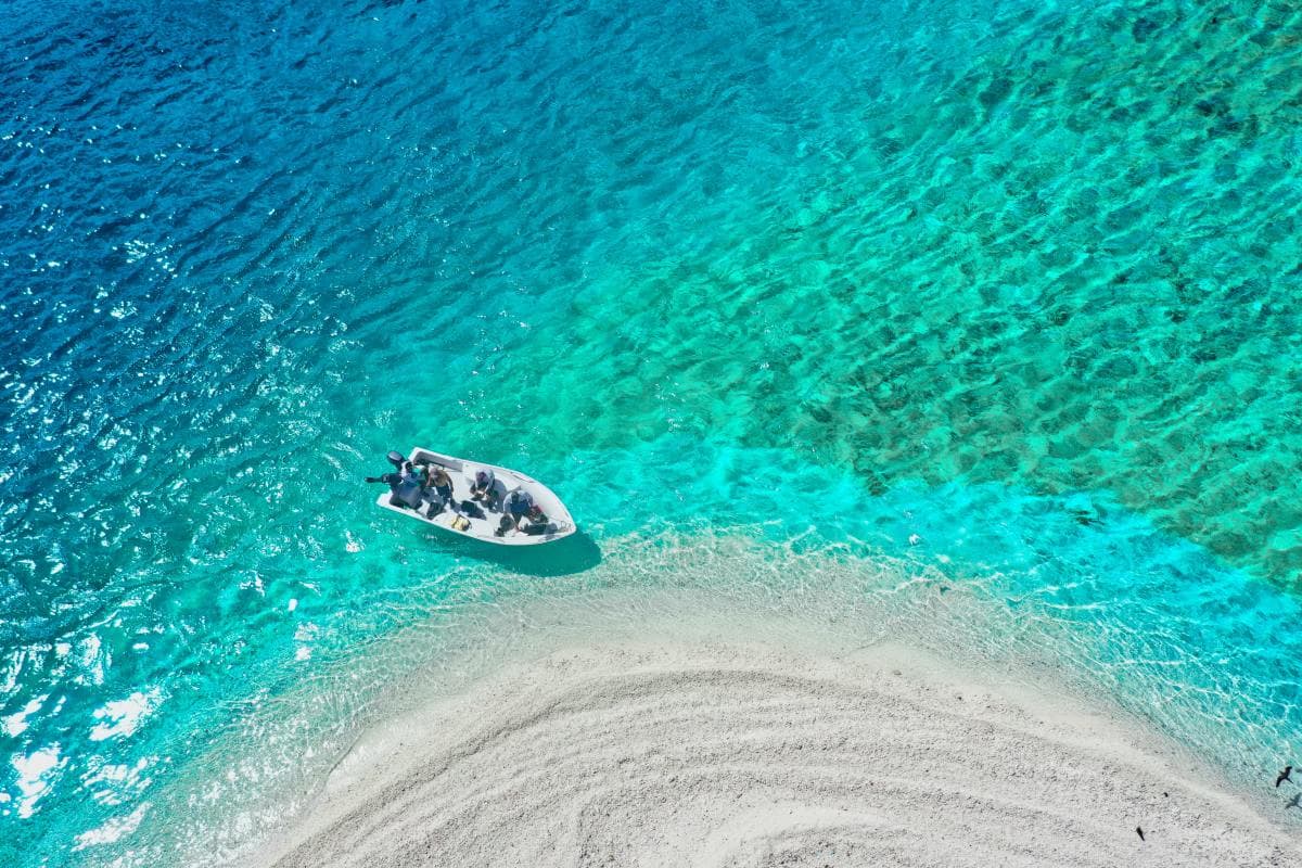 Boat on crystal clear turquoise water in the Caribbean Island of St. Martin on a sunny day.