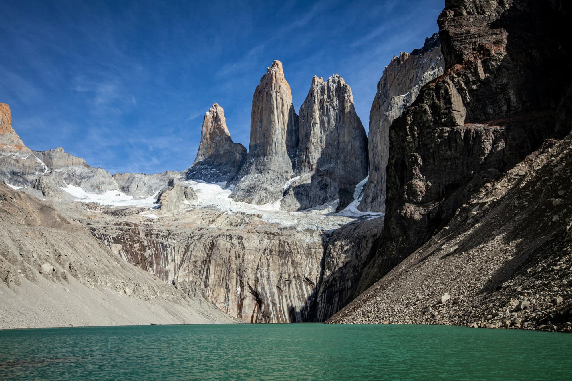 tall mountains with a stone ledge leading down to a blue lake