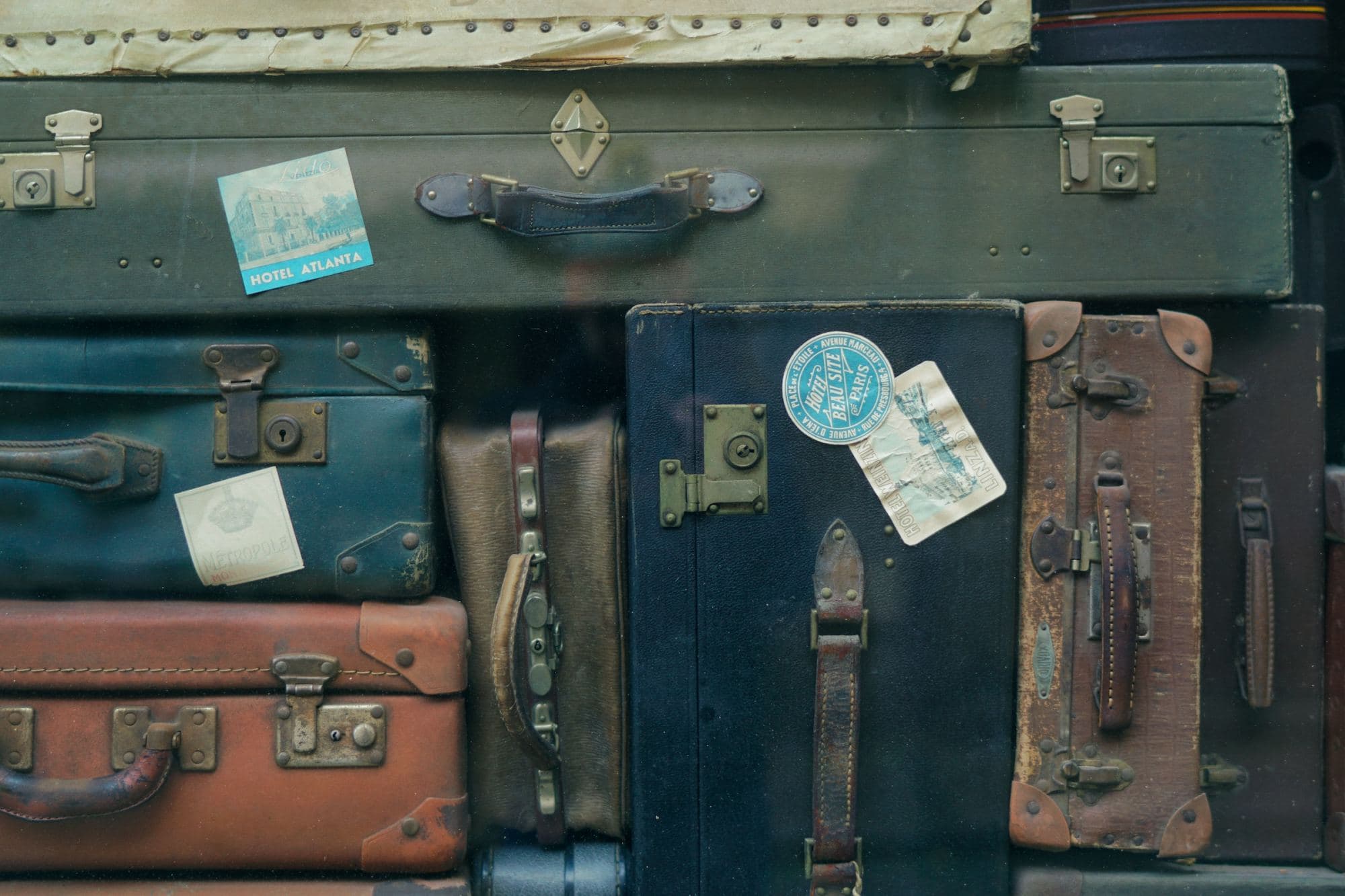 A collection of colorful vintage suitcases stacked Tetris-style (photo by Erwan Hesry)