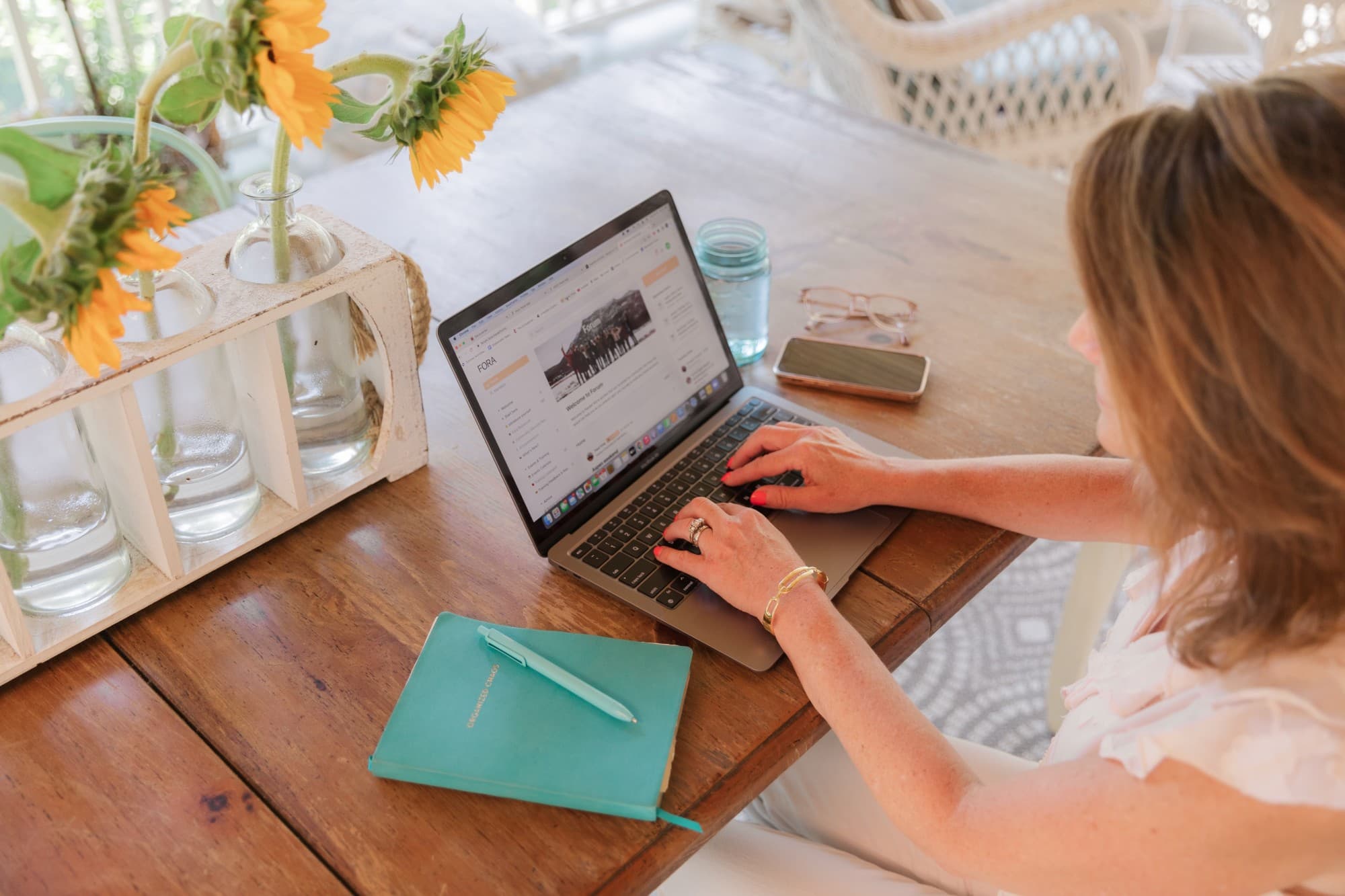 looking down on desk with computer and woman typing