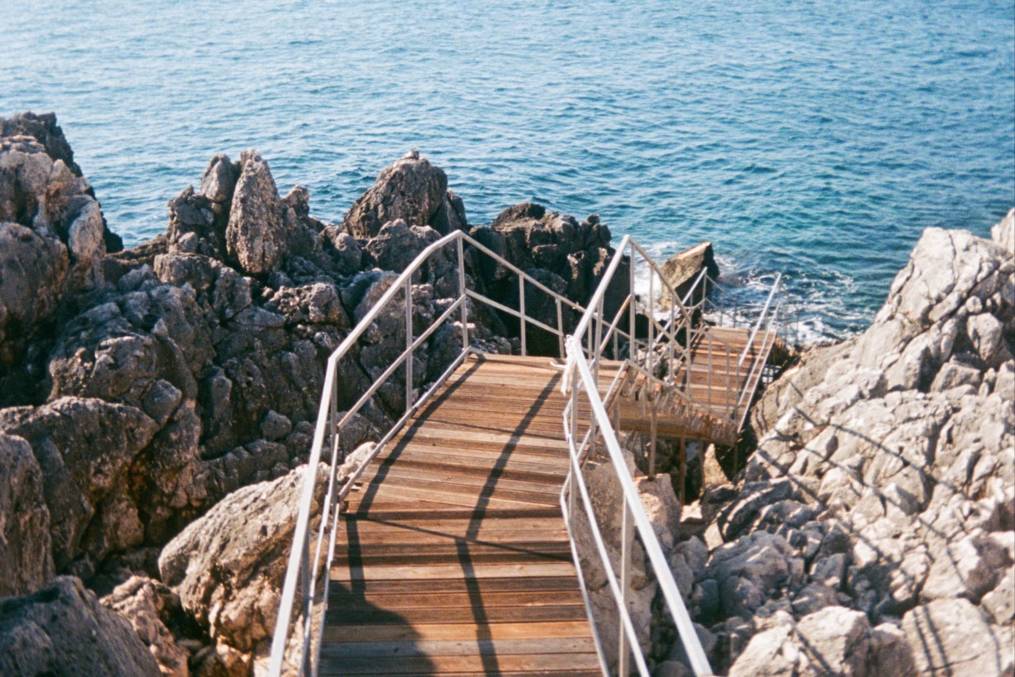 a wooden pathway leading to the sea