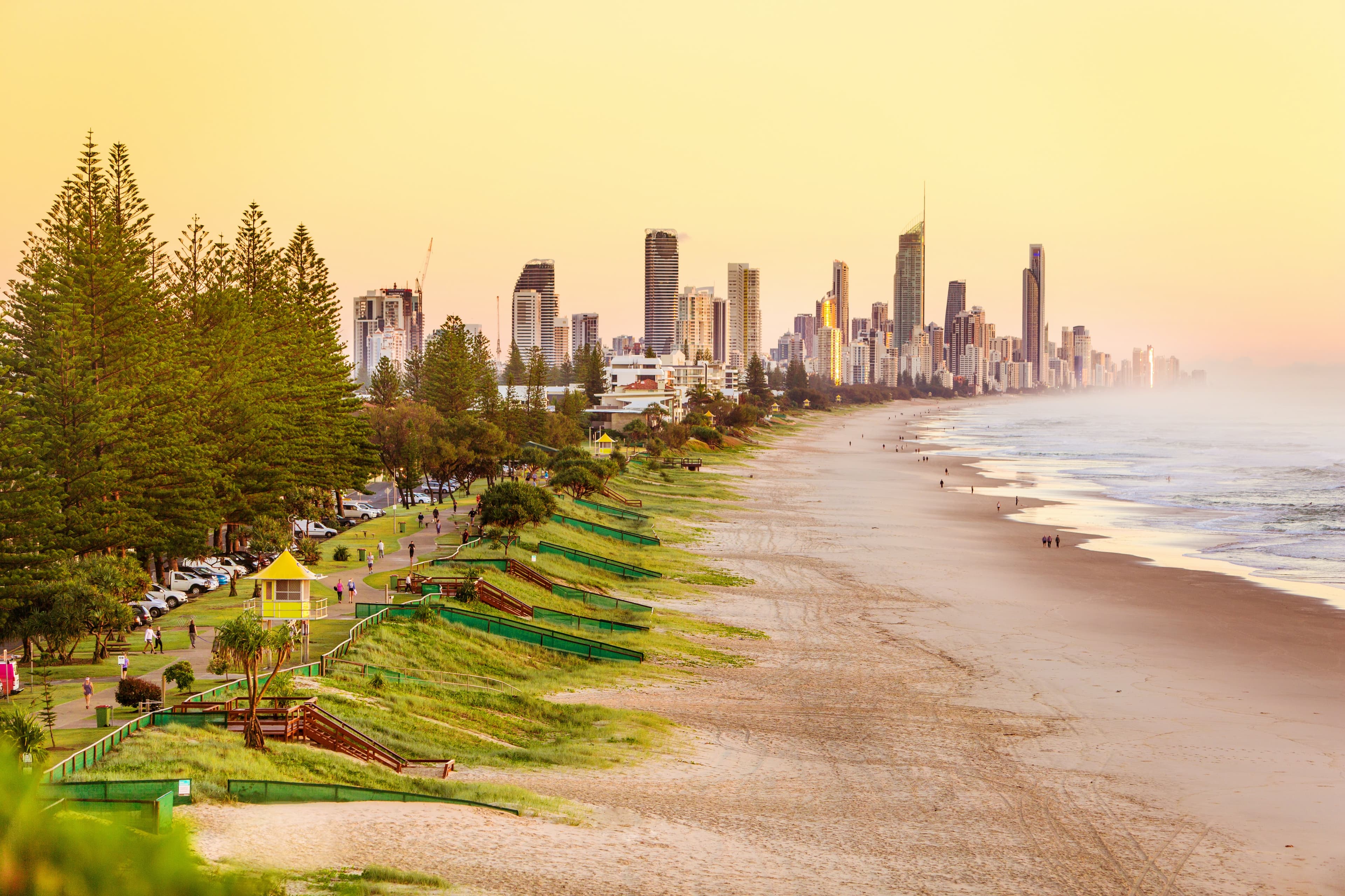 beach next to body of water with city skyline in the background