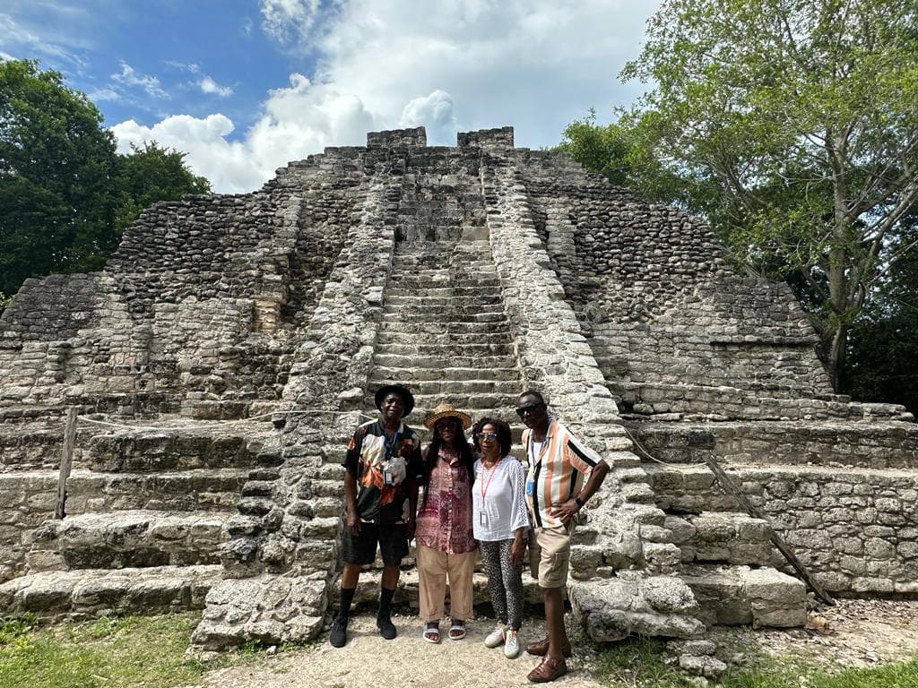 Group of people posing in front of ruins of an old architecture
