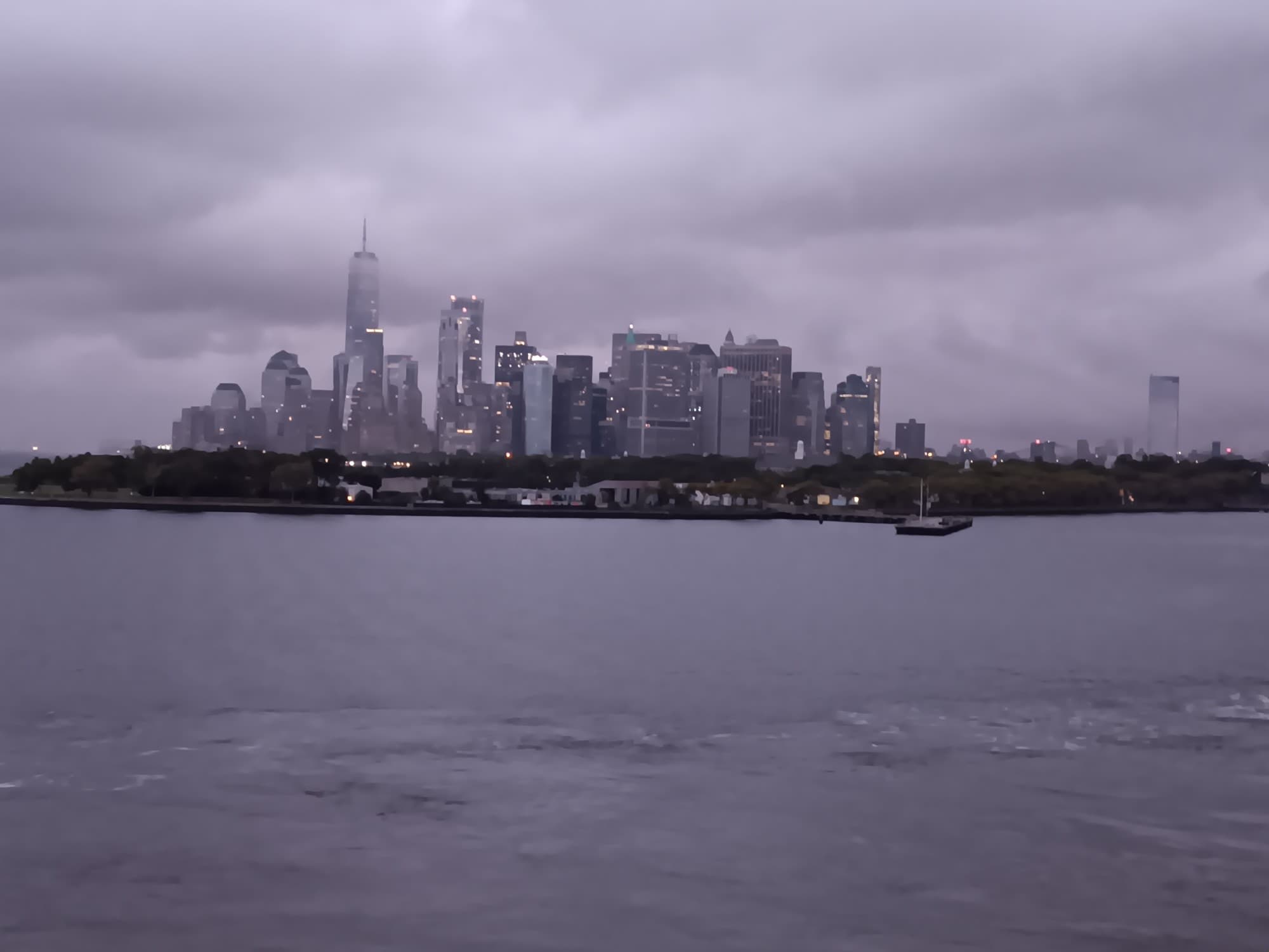 A view of a city skyline from the water during a cloudy day