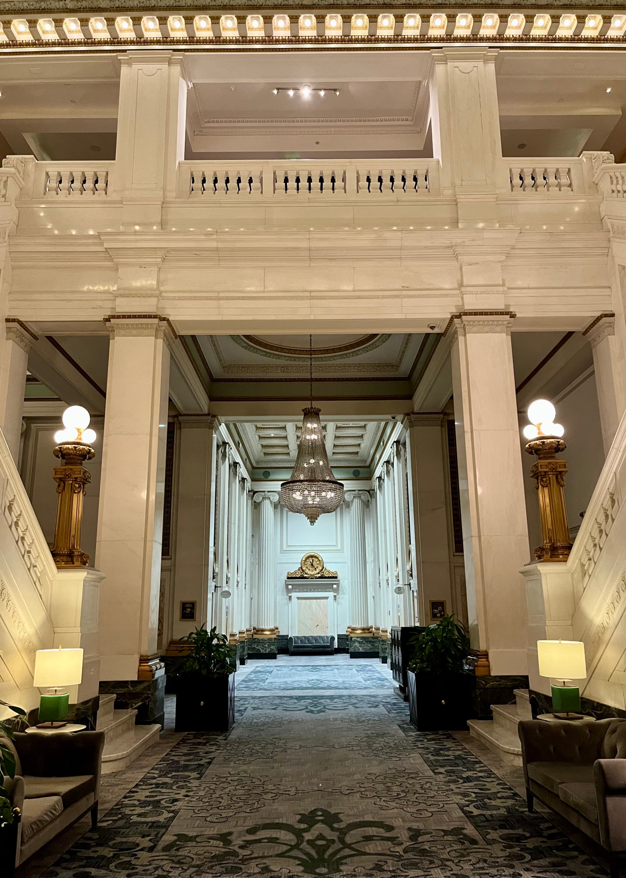 Interior of the hotel with a patterned tile floor and a crystal chandelier.