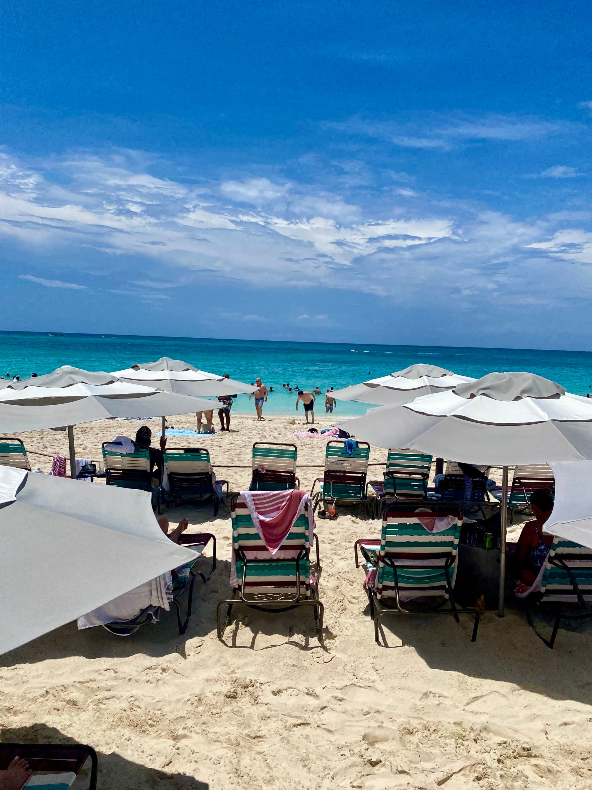 Beach chairs and umbrella sitting on the beach facing the water during the daytime