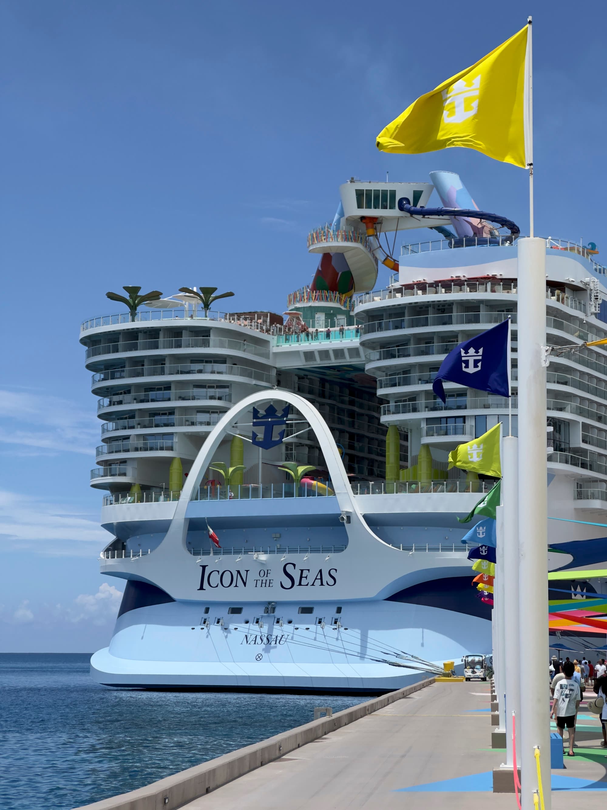 Royal Caribbean's Icon of the Seas docked in the harbor on a sunny day.