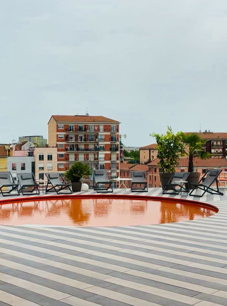 Outside pool area with lounge chairs and cloudy skies.