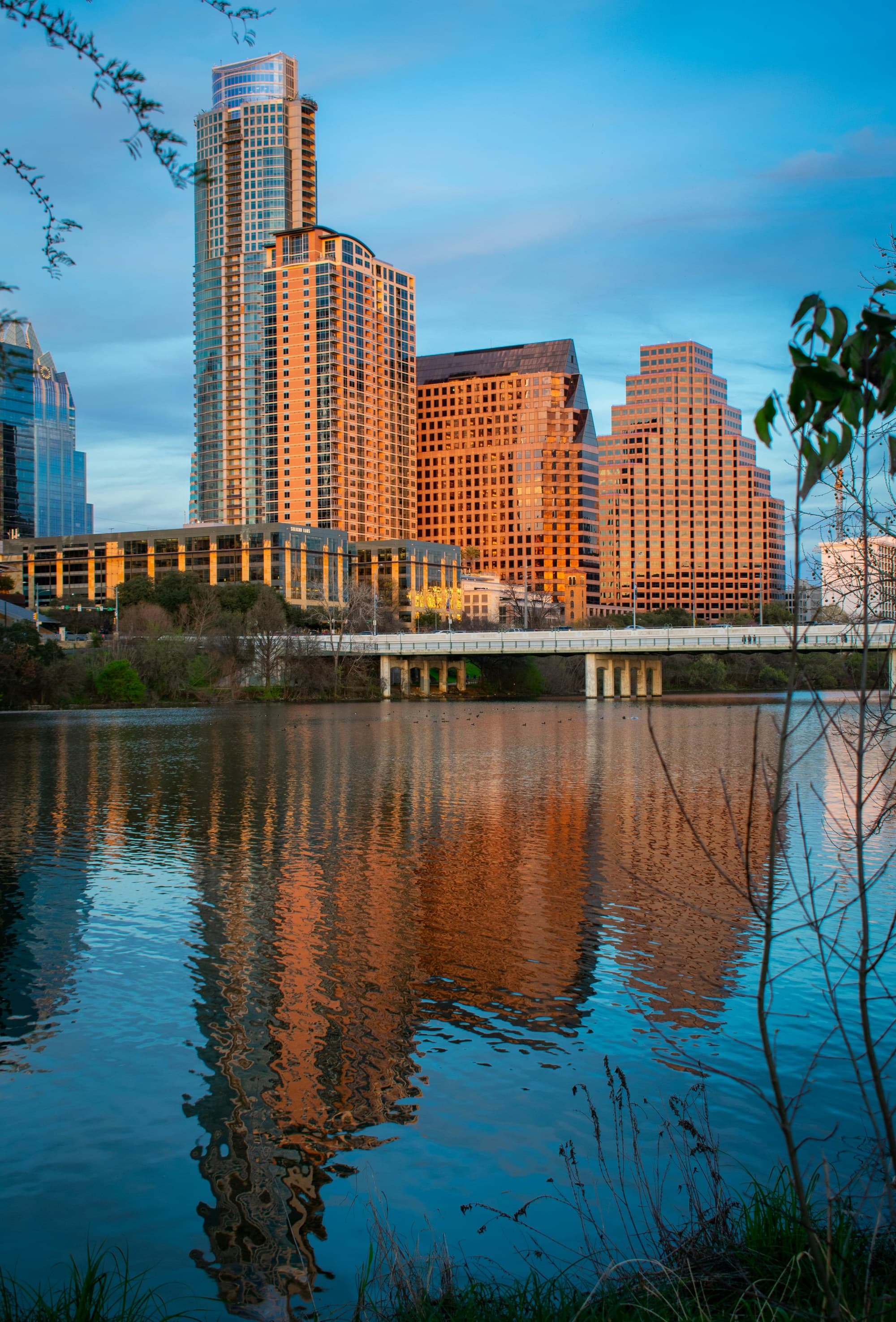 Lakeside front in Austin, Texas with orange sunset hues on the downtown buildings.