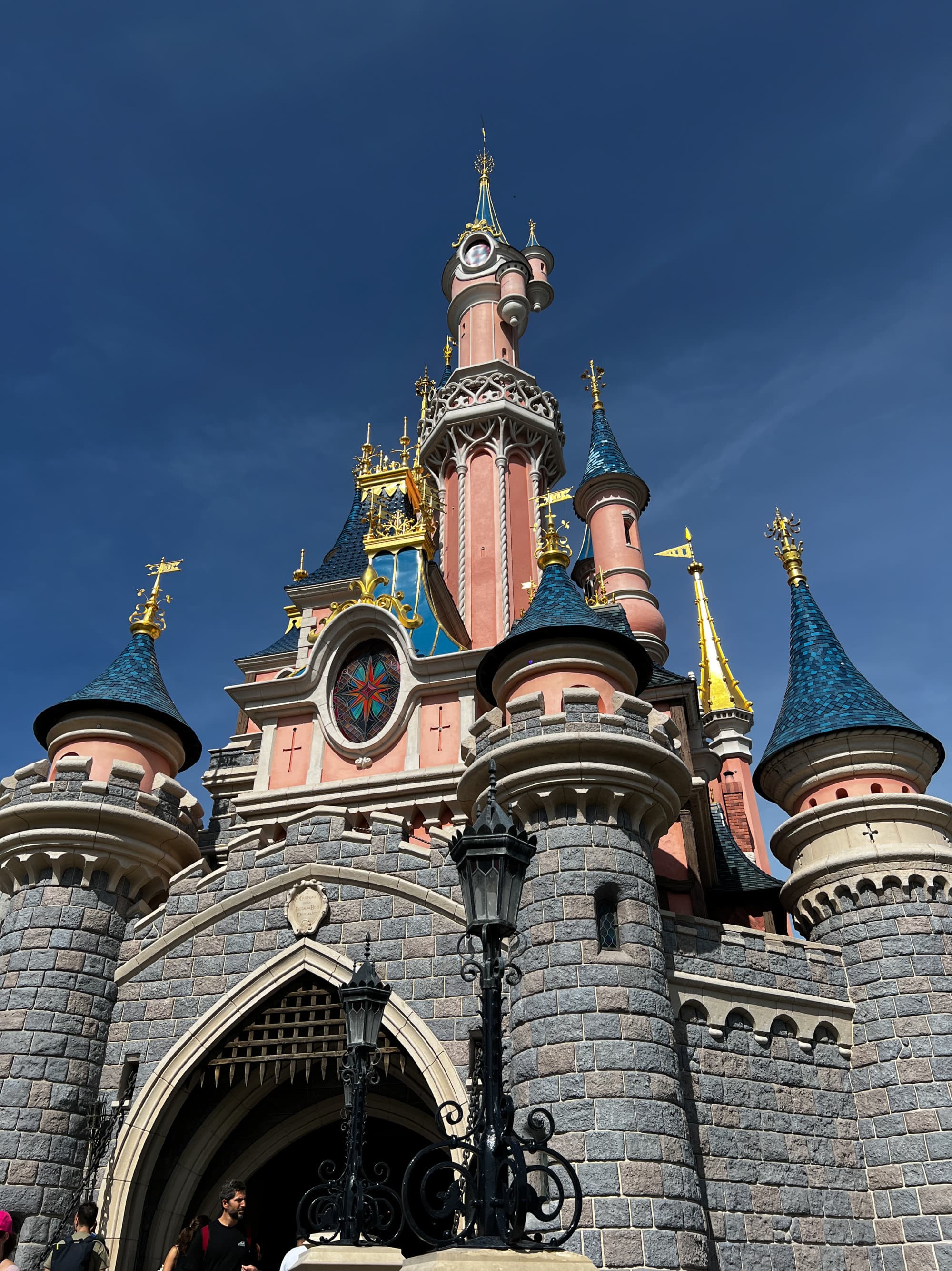 A ground view of the Disneyland Paris castle amid a clear, cloudless sky.
