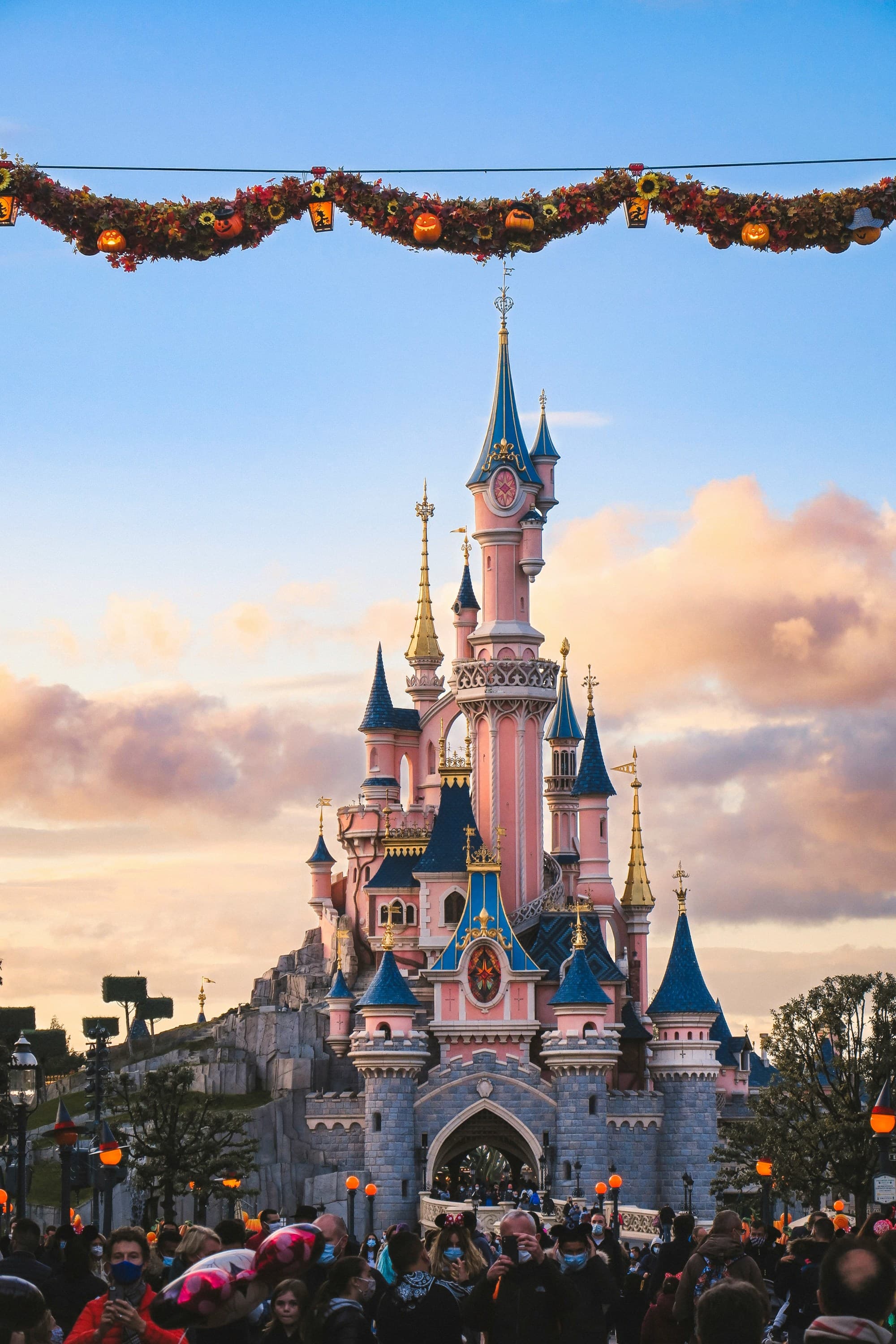A pink and blue castle at Disneyland Paris during the daytime
