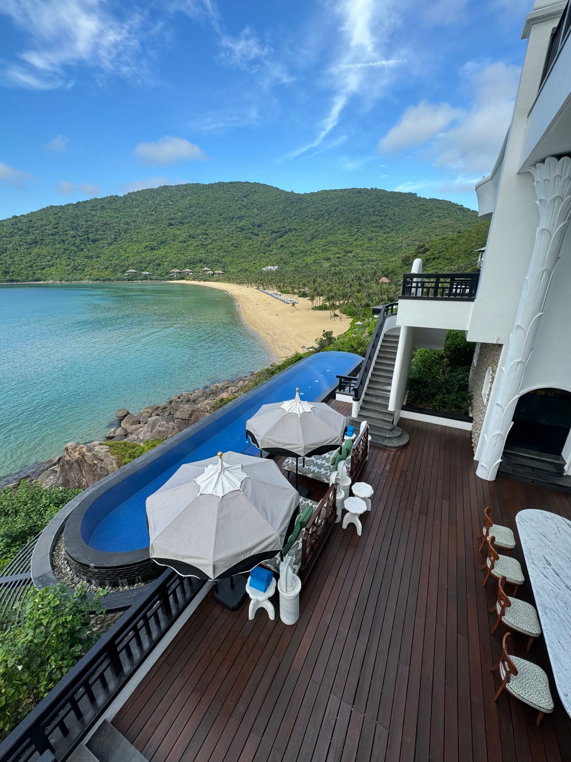 The hotel patio with two umbrellas and pool overlooking the ocean.