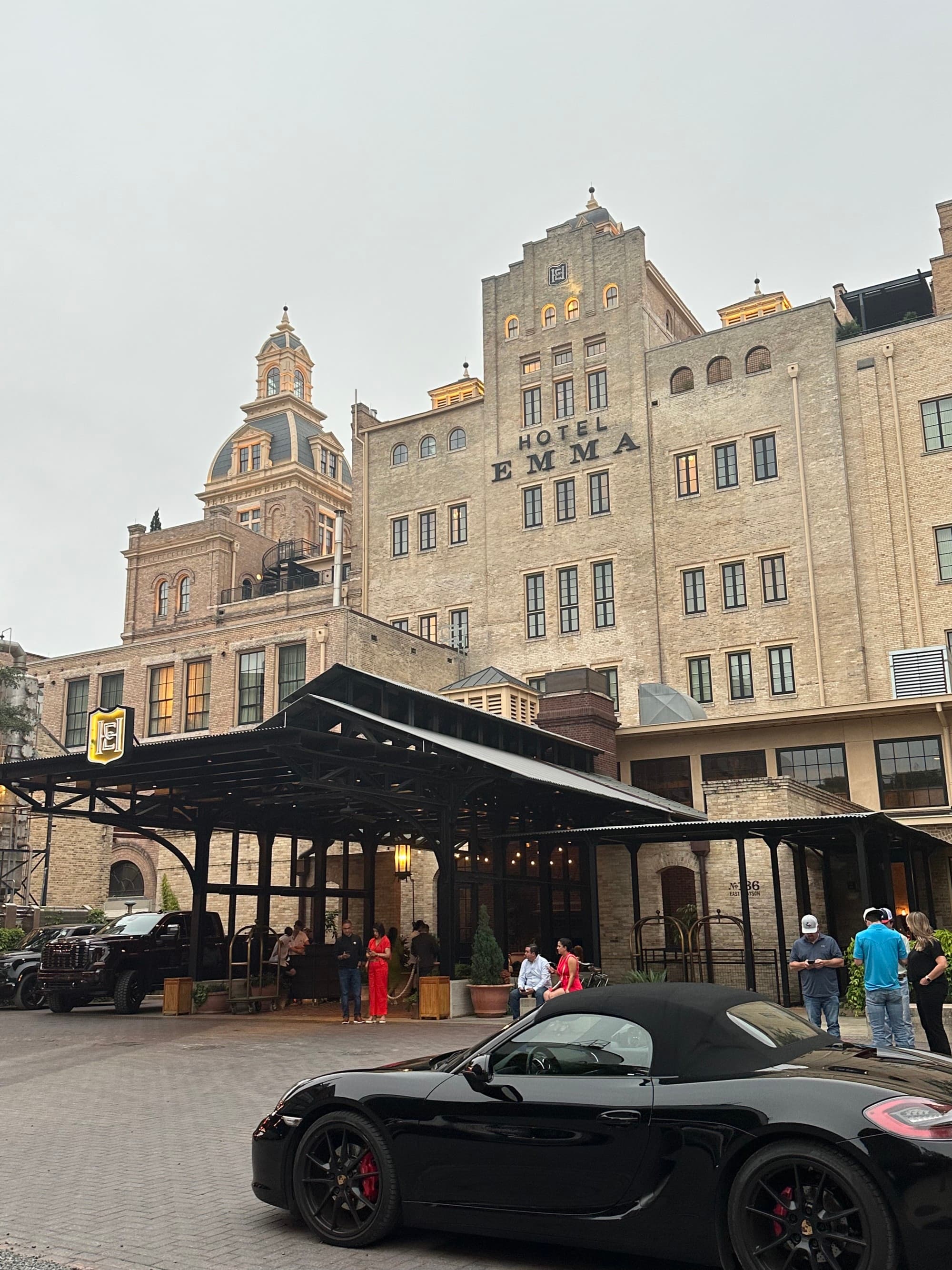 The entrance to the Hotel Emma Building, an ornate tan, stone, multi-level building with a large covered, drive-up entrance.