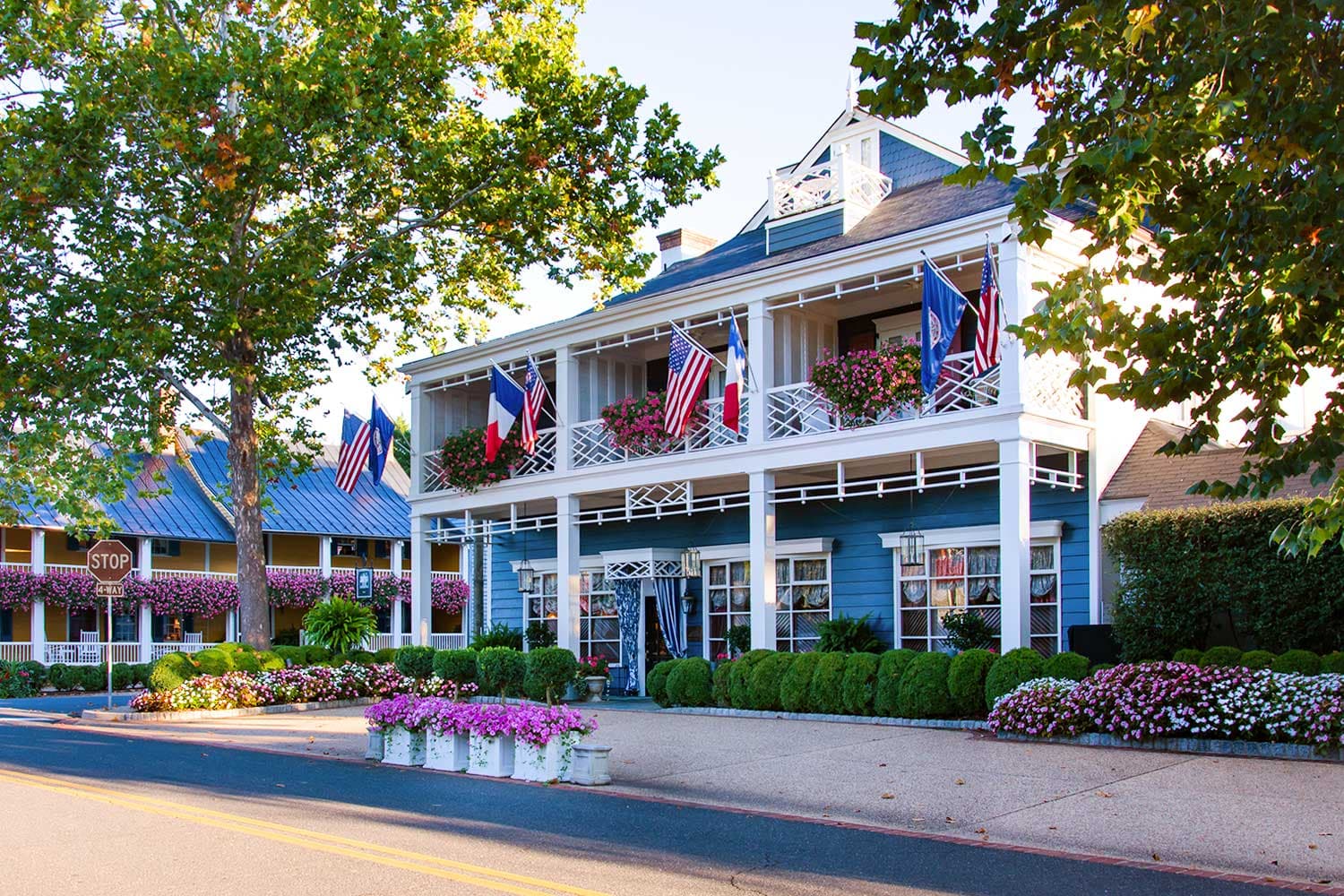 The Inn at Little Washington’s Restaurant & Conservatory on a sunny day with flags outside and large outside decks.