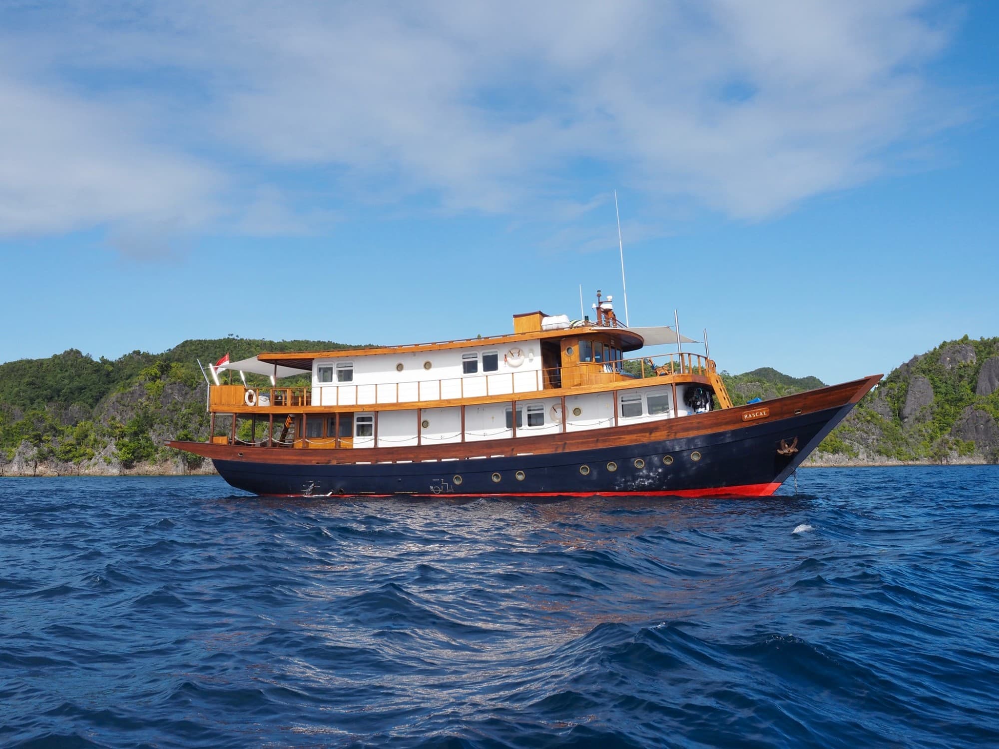 A long boat in a body of water during the daytime