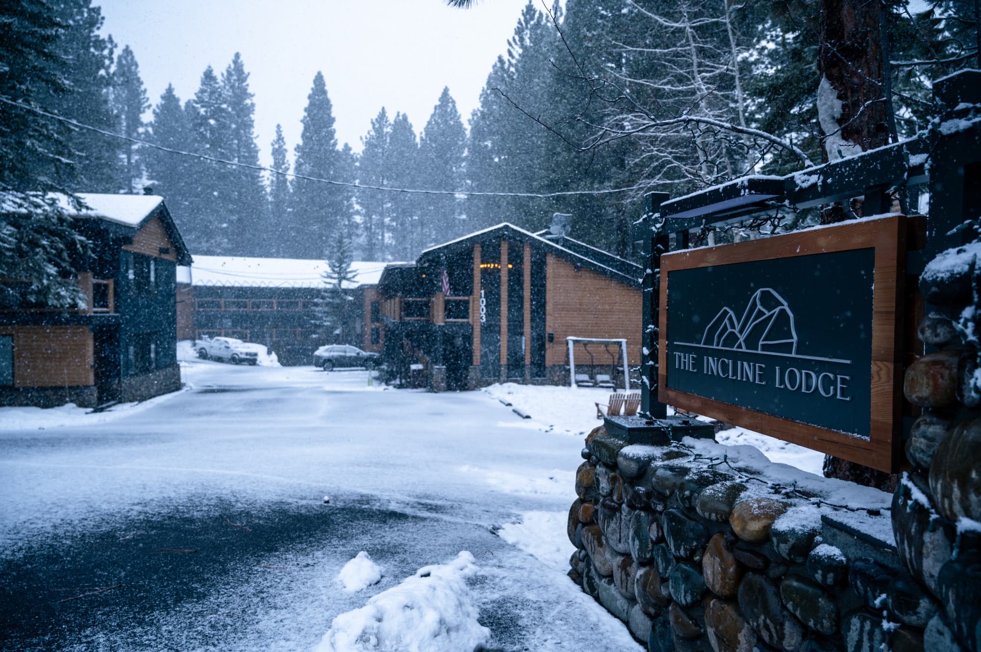 A hotel property in the snow with a sign for the hotel in the front