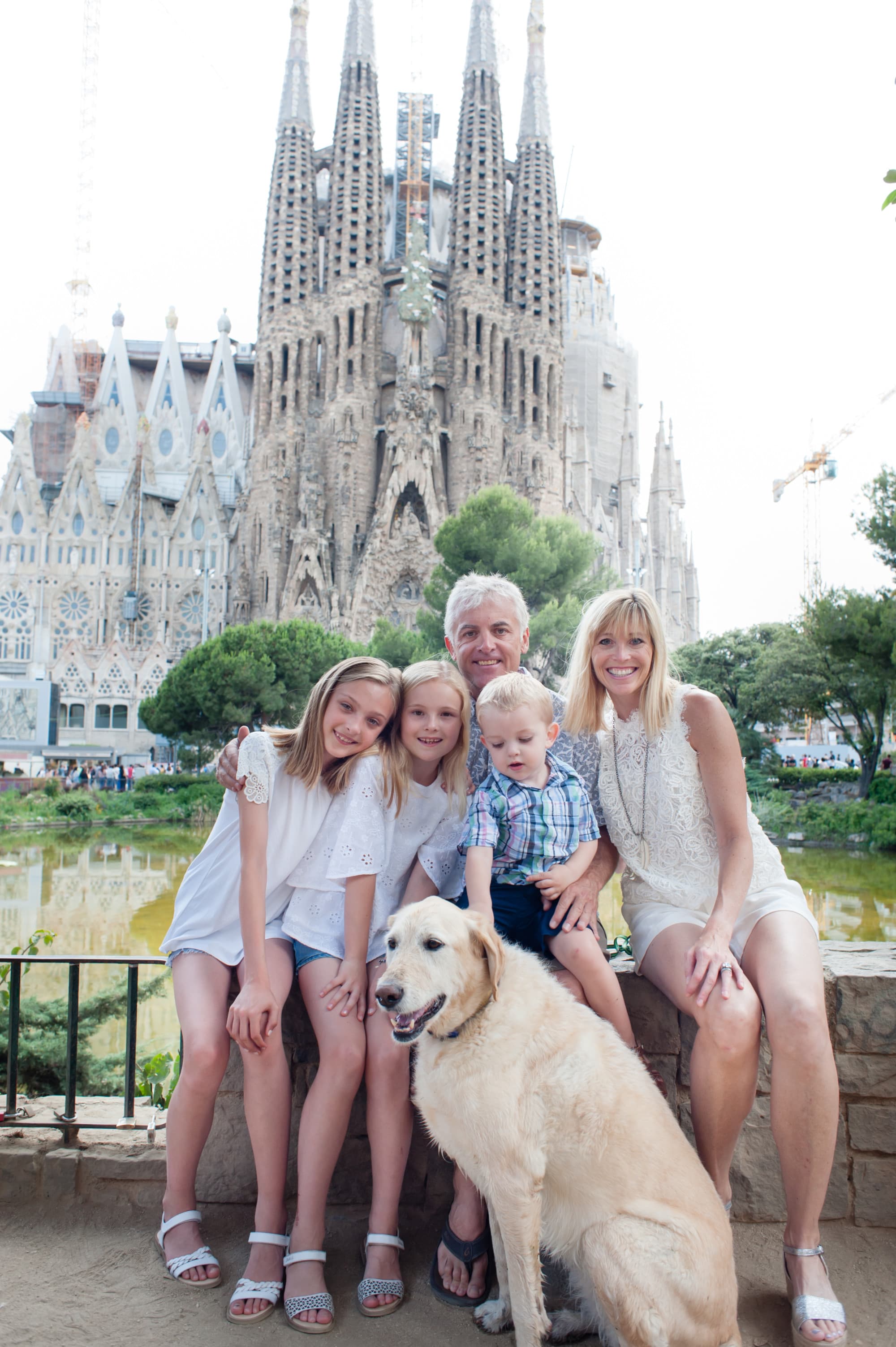 A view of Jill, a man, three kids and a dog posing in front of a popular tourist attraction in Barcelona, Spain.