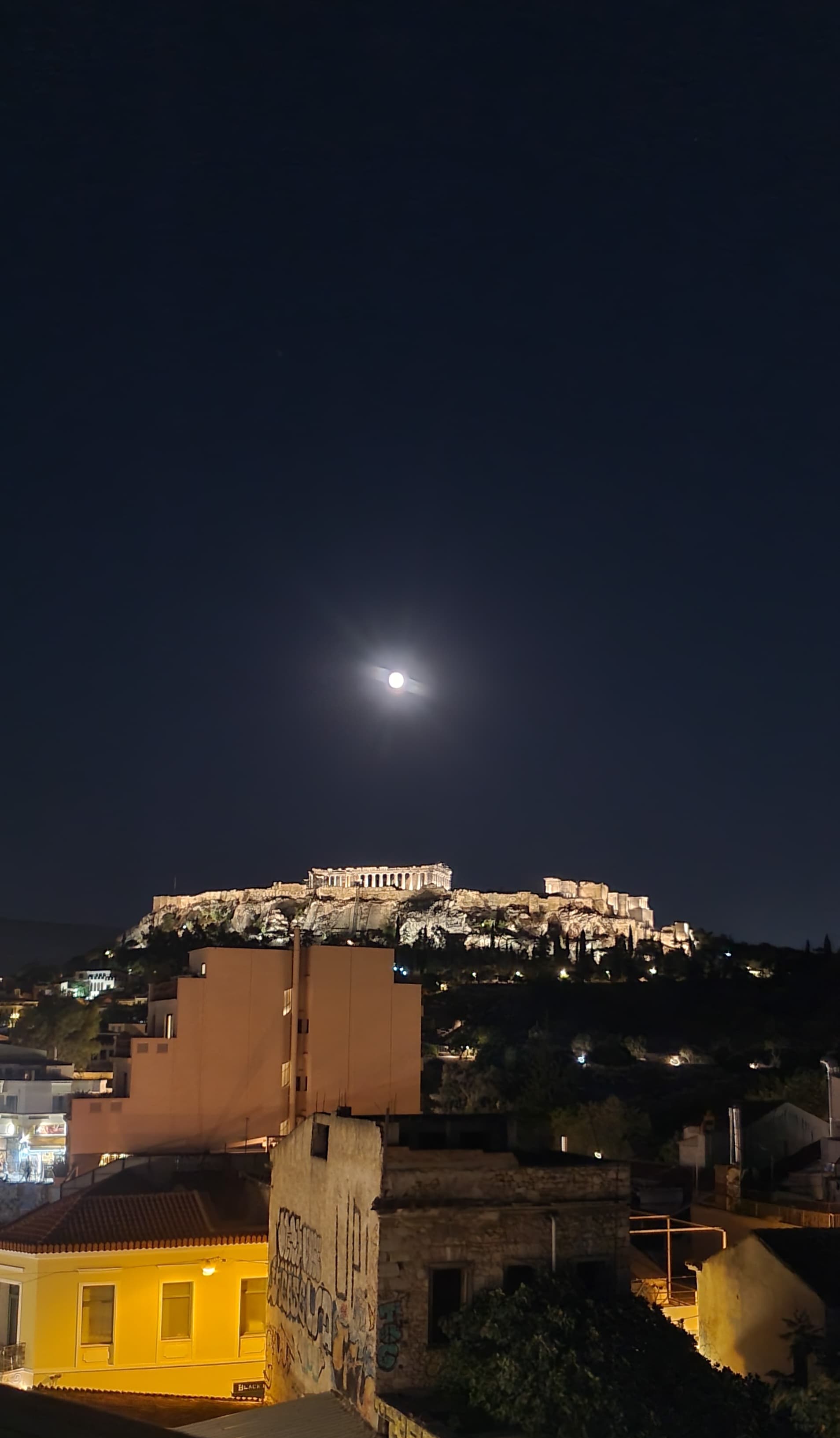 The moon shines high in the sky on a clear night.
