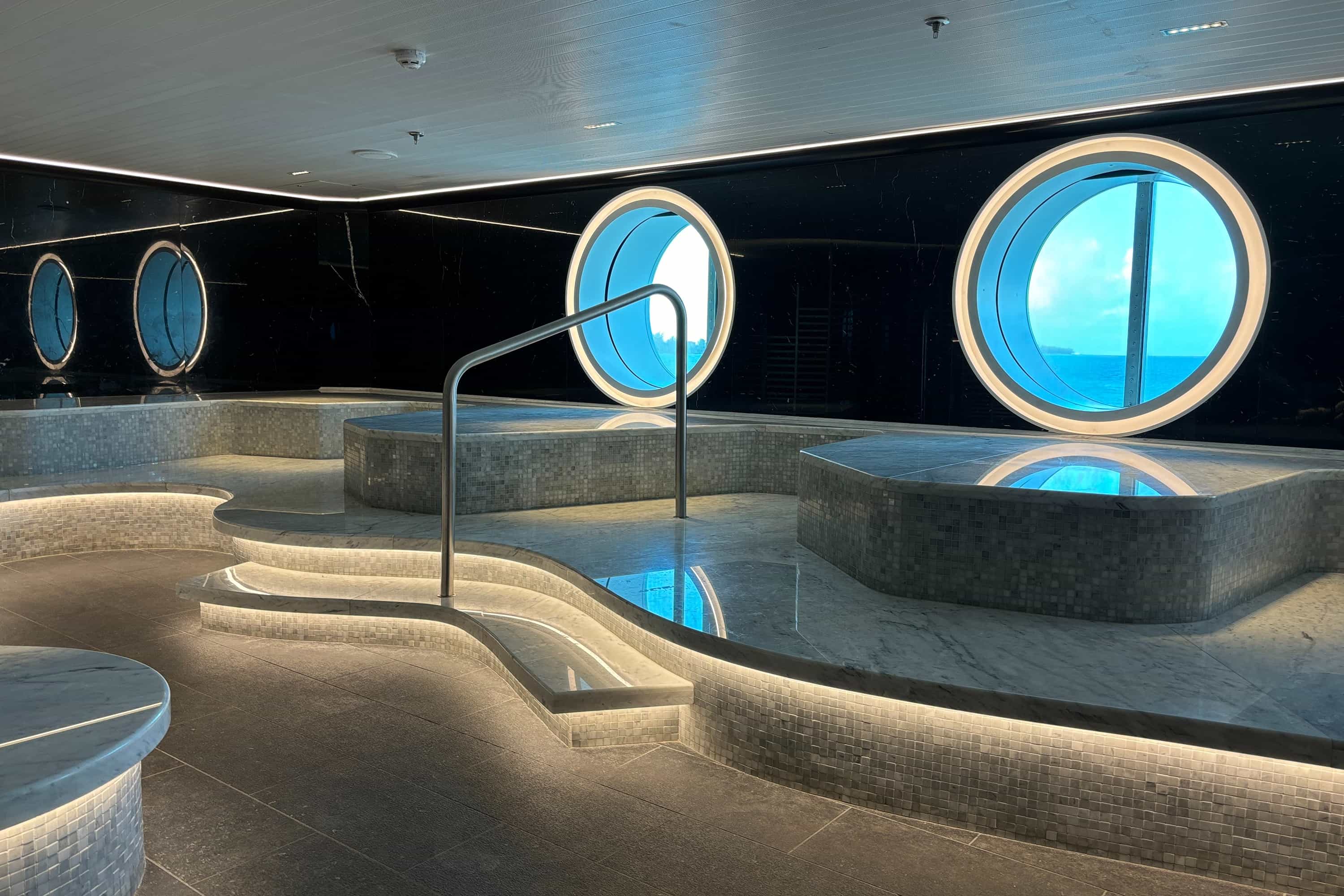 Virgin Voyages' thermal suite, with stone benches next to portholes.