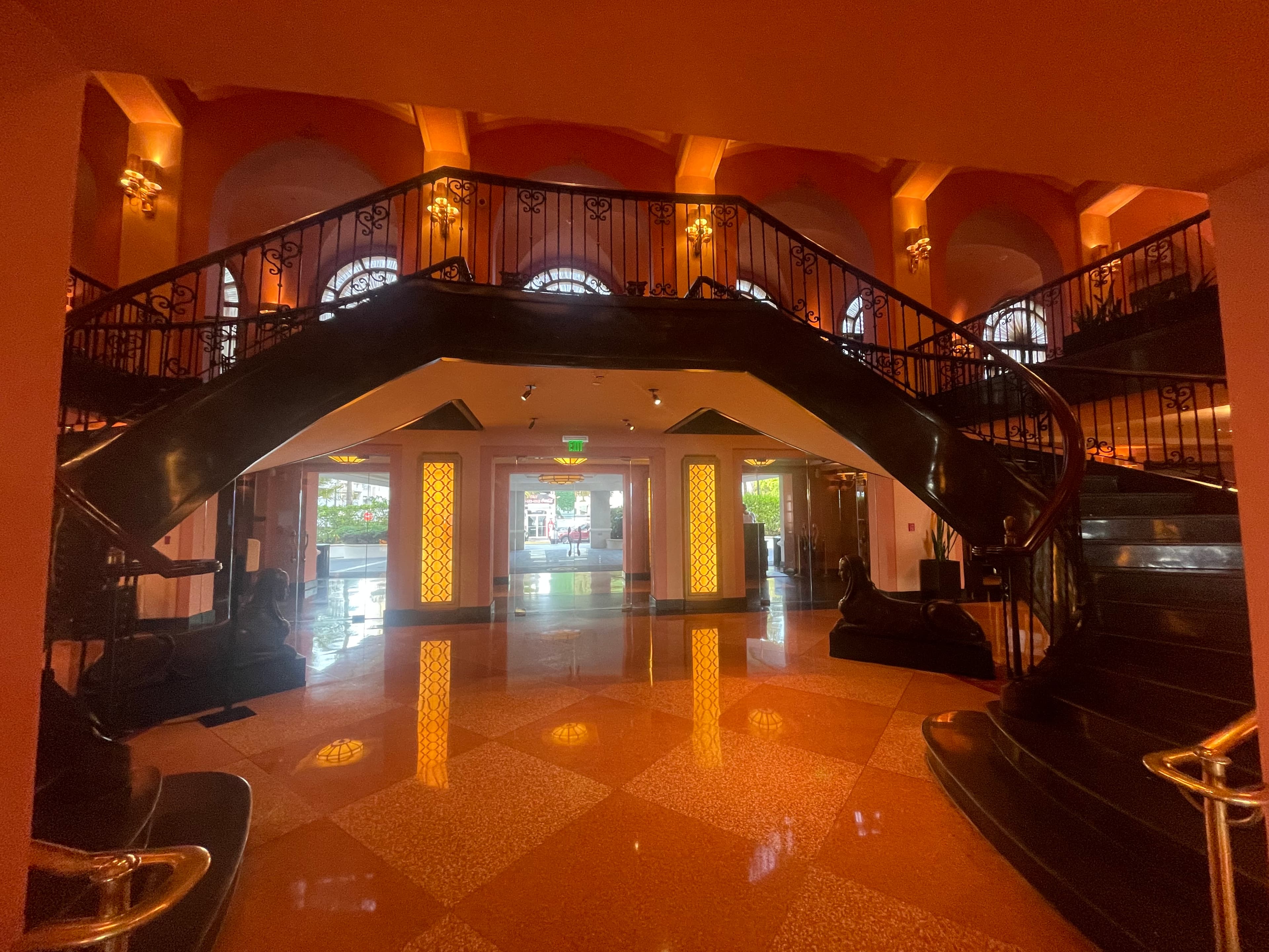 A staircase in a hotel lobby with dark orange lighting