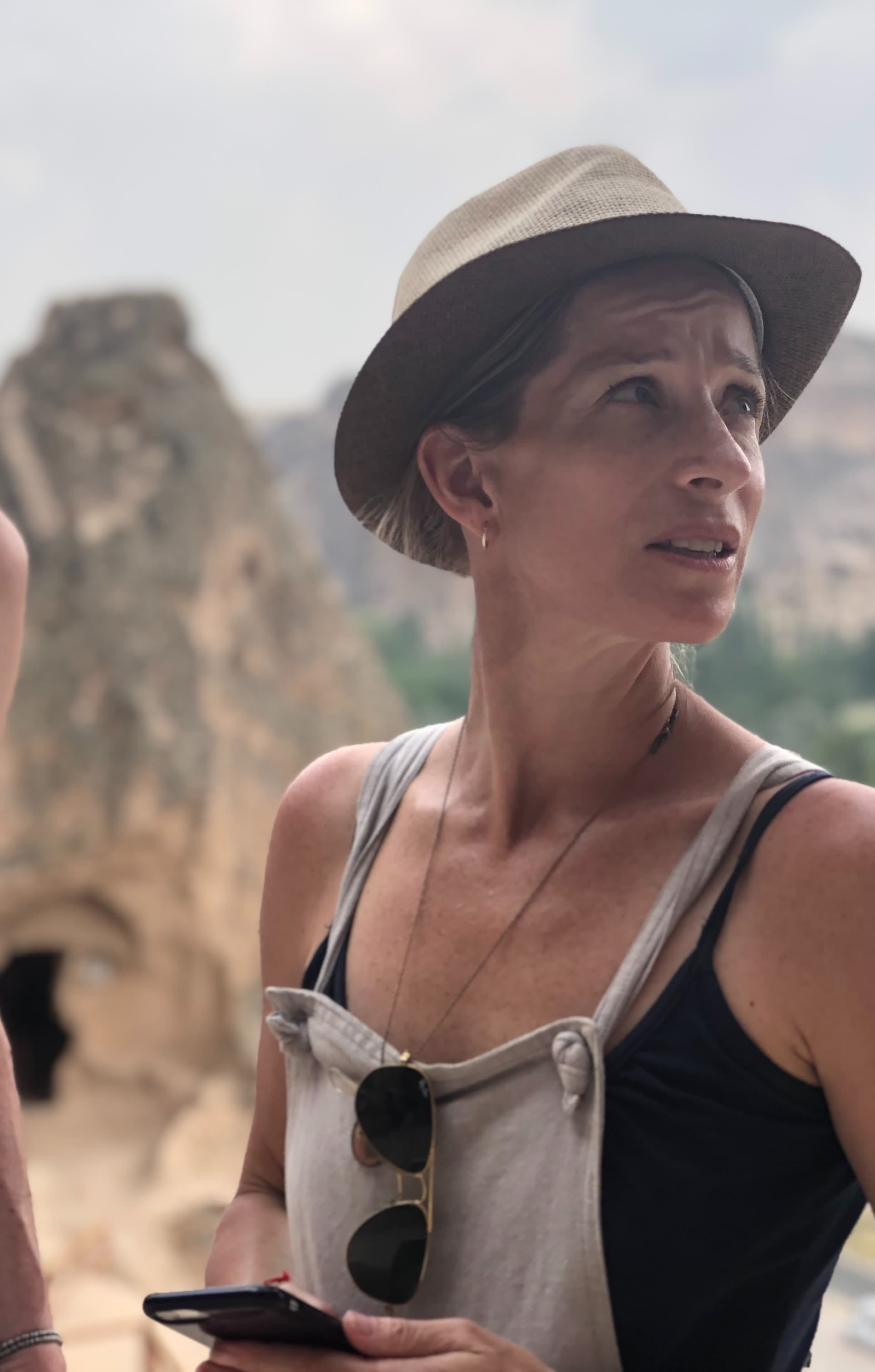 Two people standing in front of a view of mountains and trees outside.