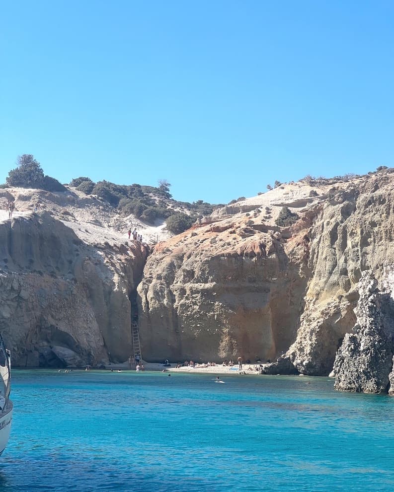 A view of turquoise blue water surrounding by rocky cliffs.