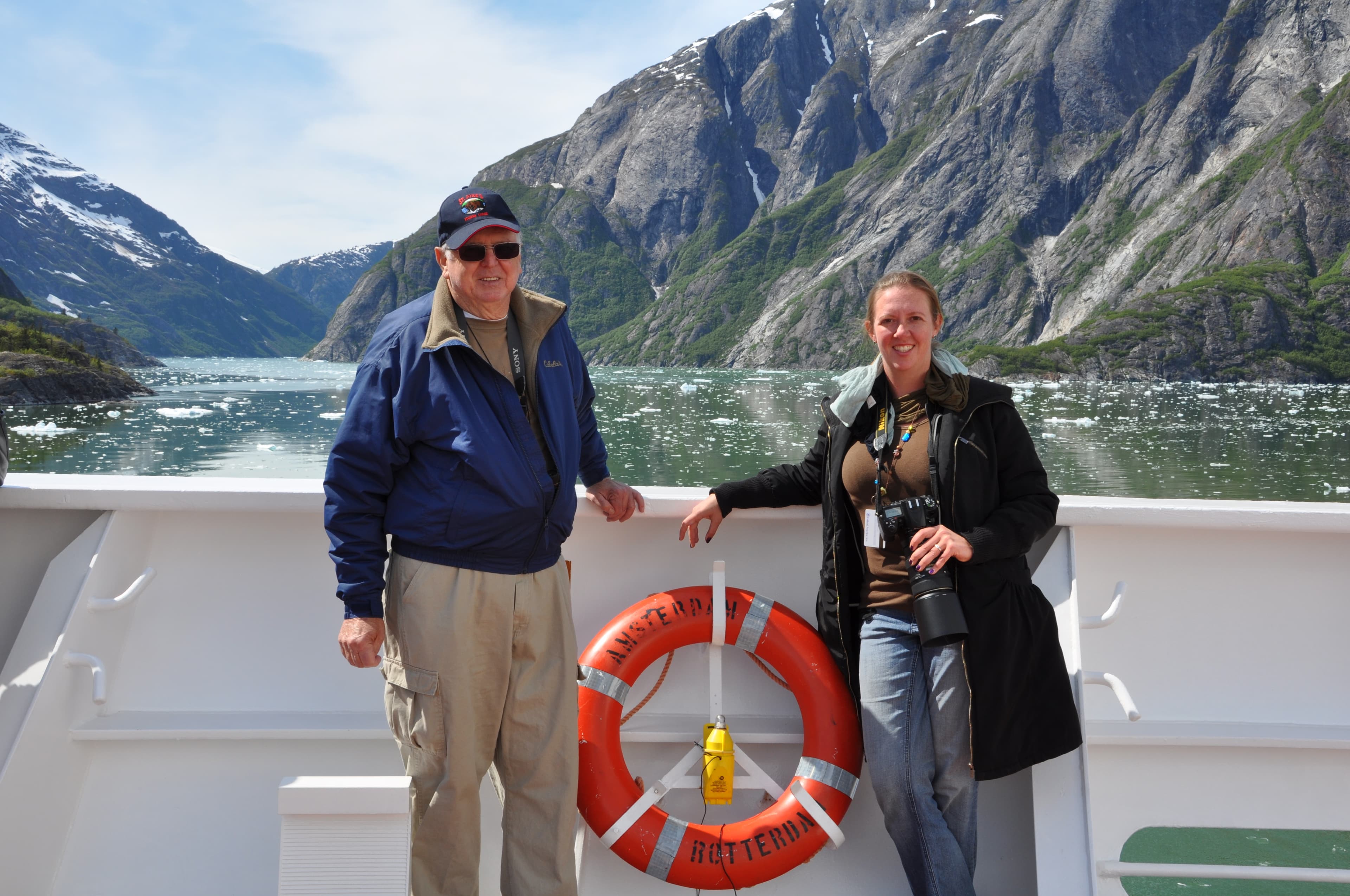 Travel advisor Tammy Mcmahon posing on a boat with a lifebuoy and mountains and lake in view