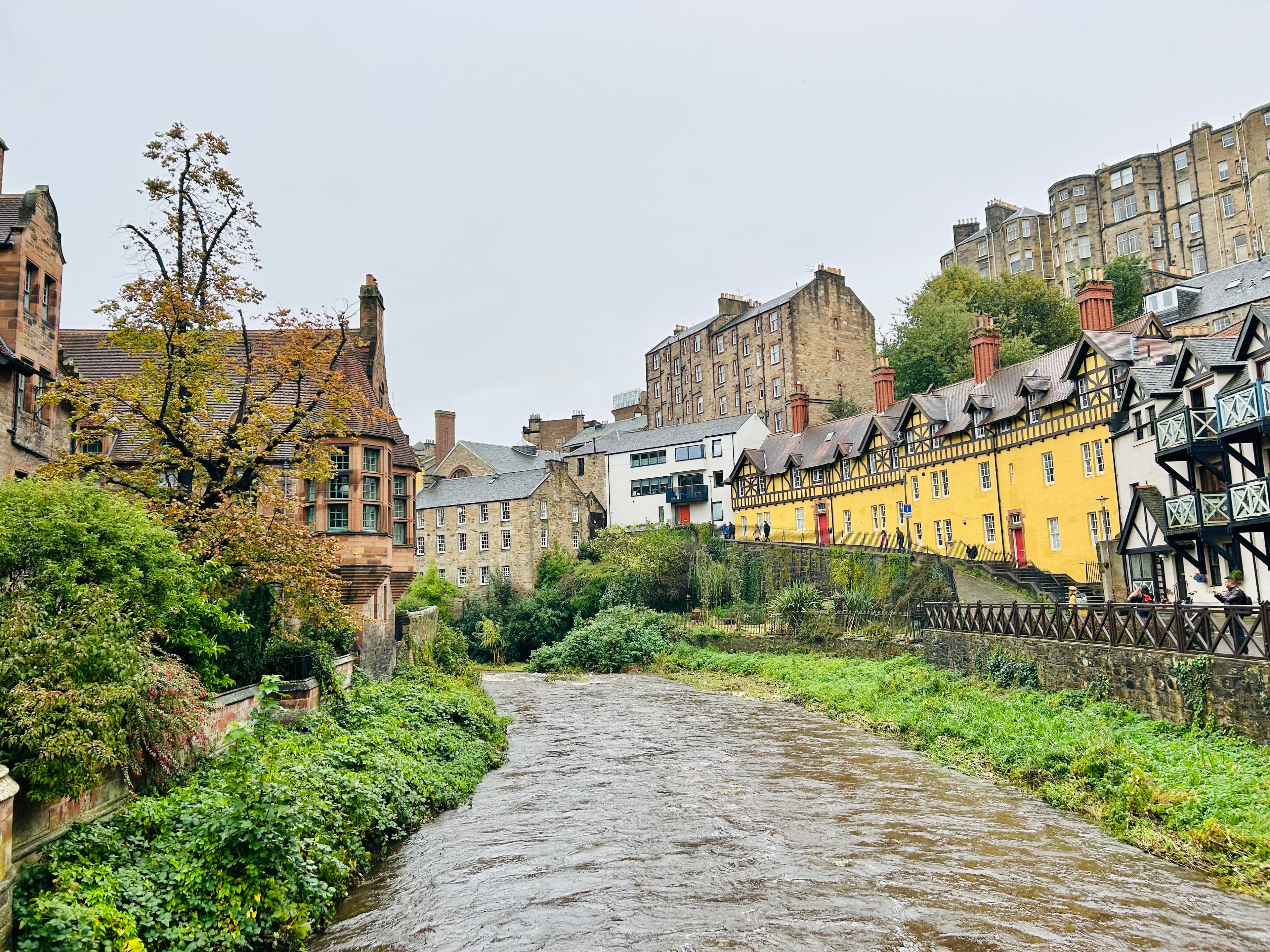 Beautiful view of pathway with greenery and yellow and brown buildngs in Dean Village