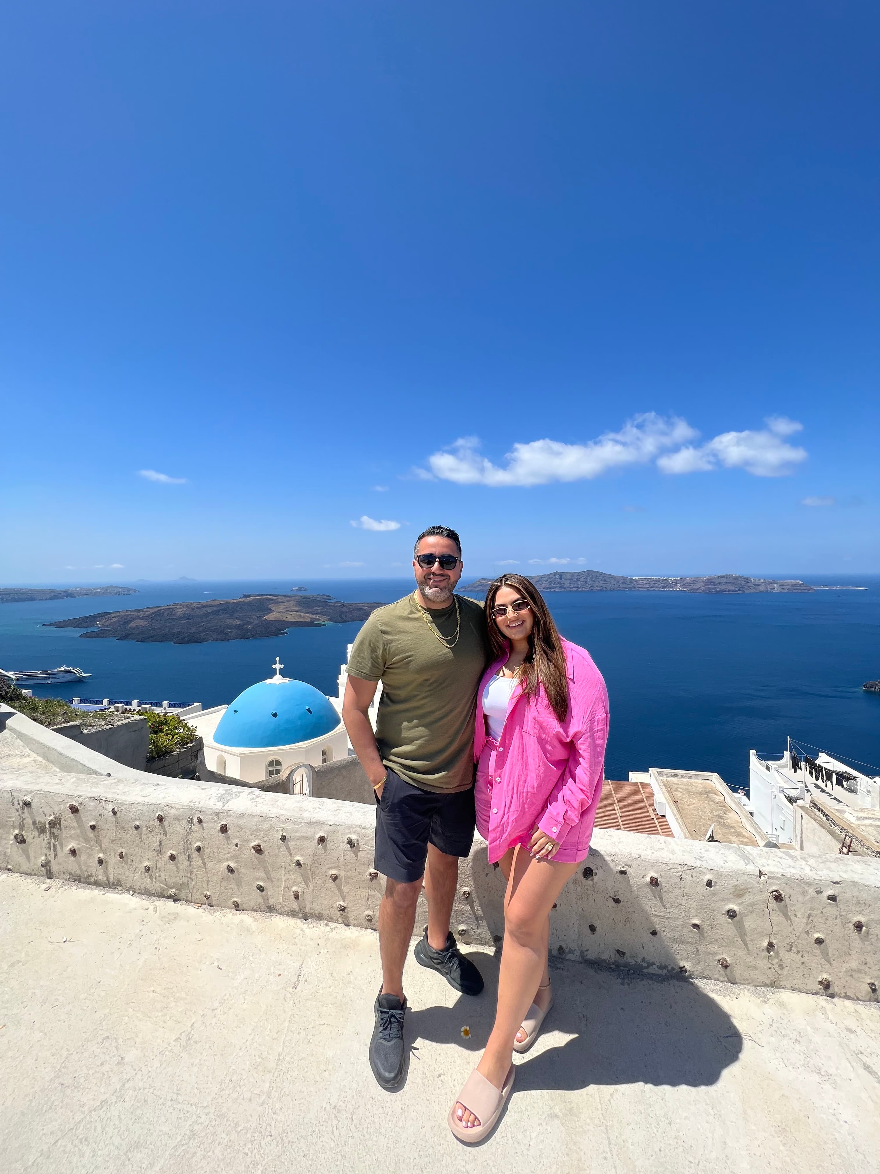 Travel advisor Riva Hanna posing for a picture with male companion in front of the ocean in Santorini
