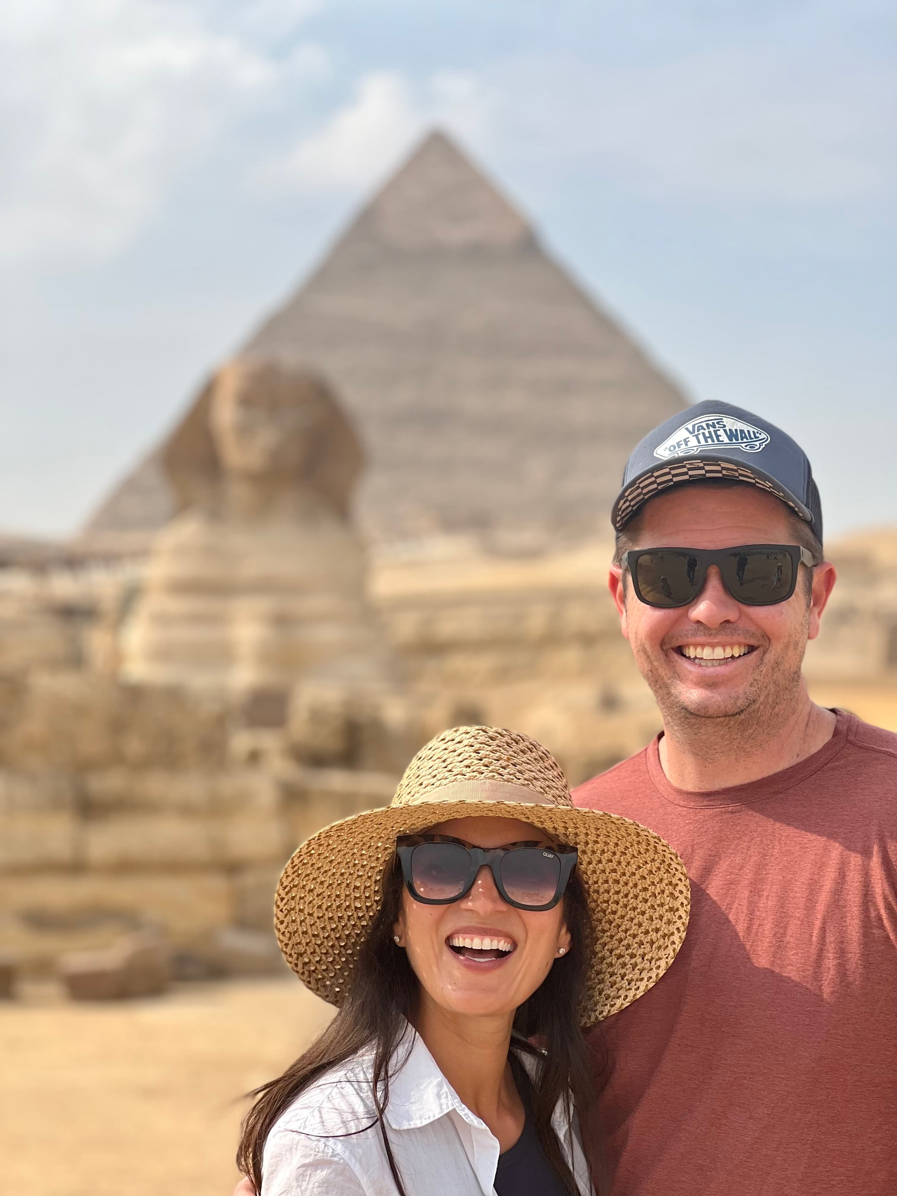 Nadiah and her husband with the pyramids in the distance.