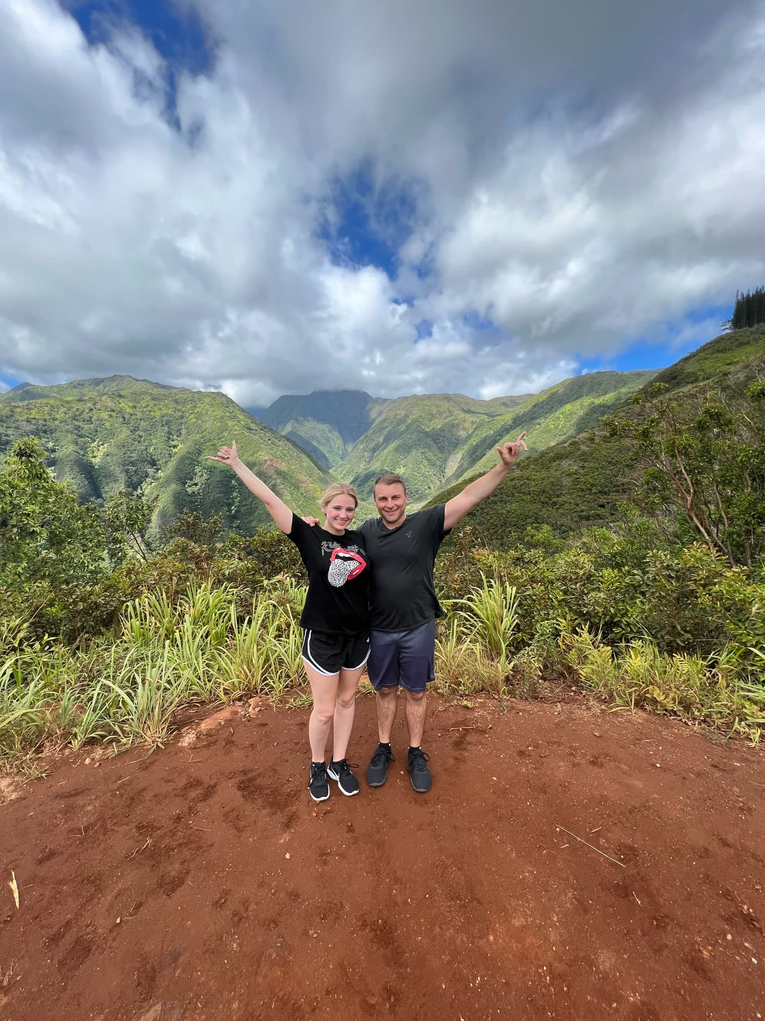 Kerry standing next to a person at the top of a green mountain